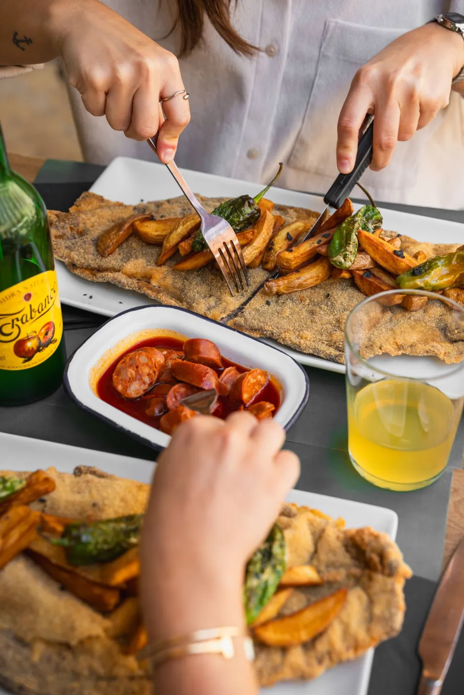 Torto de maíz con patatas y pimientos fritos junto a chorizos a la sidra y una copa de sidra
