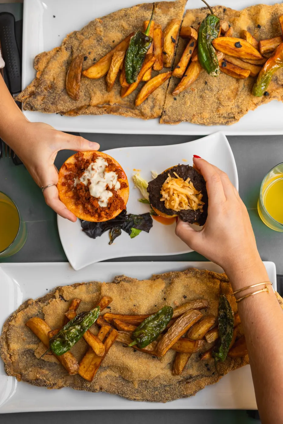 Tosta rellena de queso rodeada de tortos de maíz con patatas y pimientos