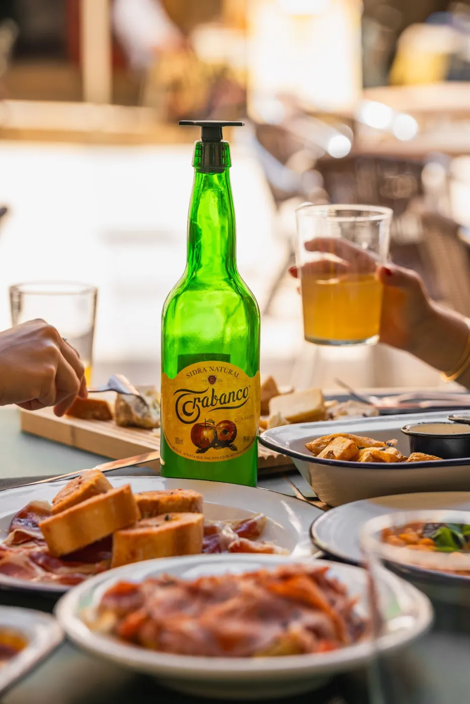 Brindis con sidra natural en una mesa compartida al atardecer en La Kchoperia